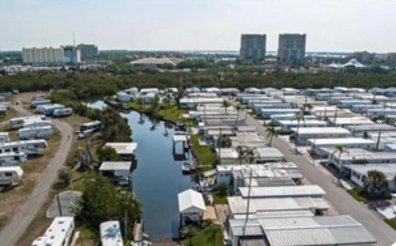An aerial view shows a mobile home park with a central canal and nearby buildings — 144 PENNSYLVANIA STREET, PALMETTO, FL