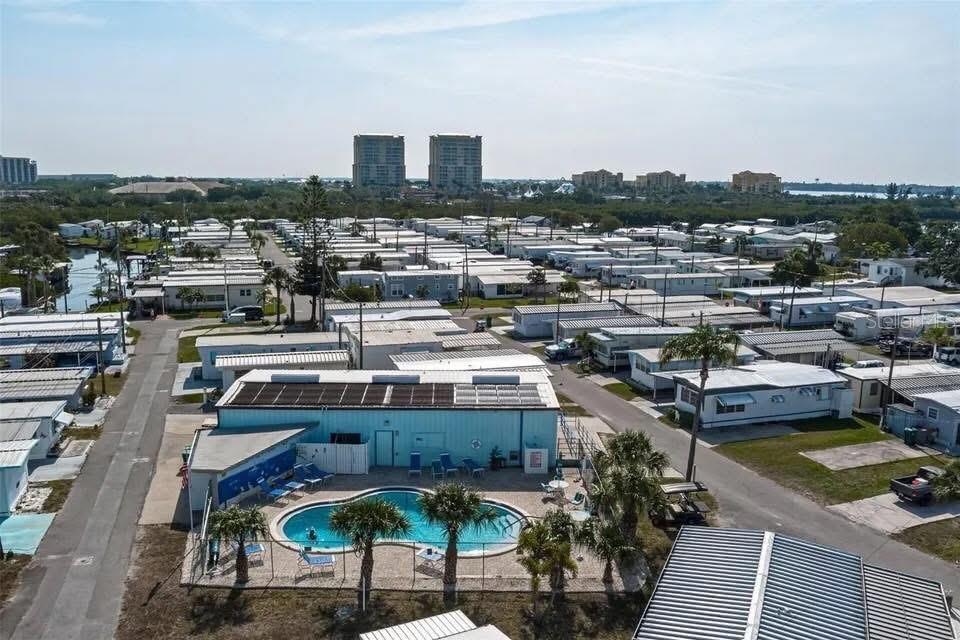 An aerial view shows a mobile home community with a central swimming pool and clubhouse — 144 PENNSYLVANIA STREET, PALMETTO, FL