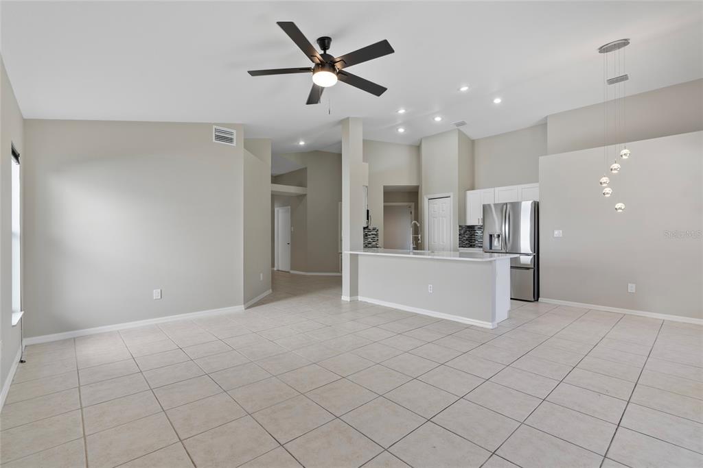 An open-concept living and kitchen area features tile flooring, a ceiling fan, and white cabinetry — 1831 ERIN BROOKE DRIVE, VALRICO, FL