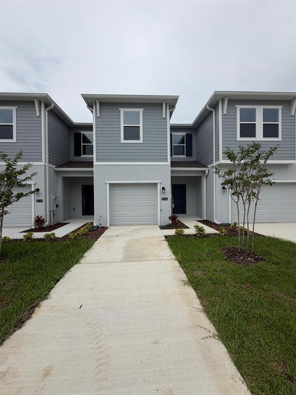 A view of the exterior of a multi-unit townhouse building with gray siding and garages — 3106 KURTZ TERRACE, DAVENPORT, FL