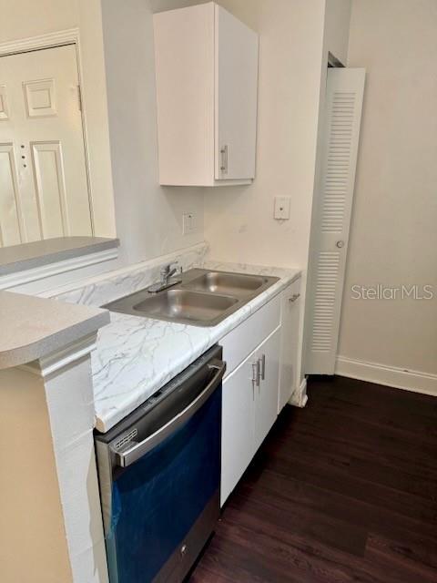 A kitchen features a stainless steel dishwasher, a double-basin sink, and white cabinets — 2521 GRASSY POINT DRIVE UNIT 101, LAKE MARY, FL