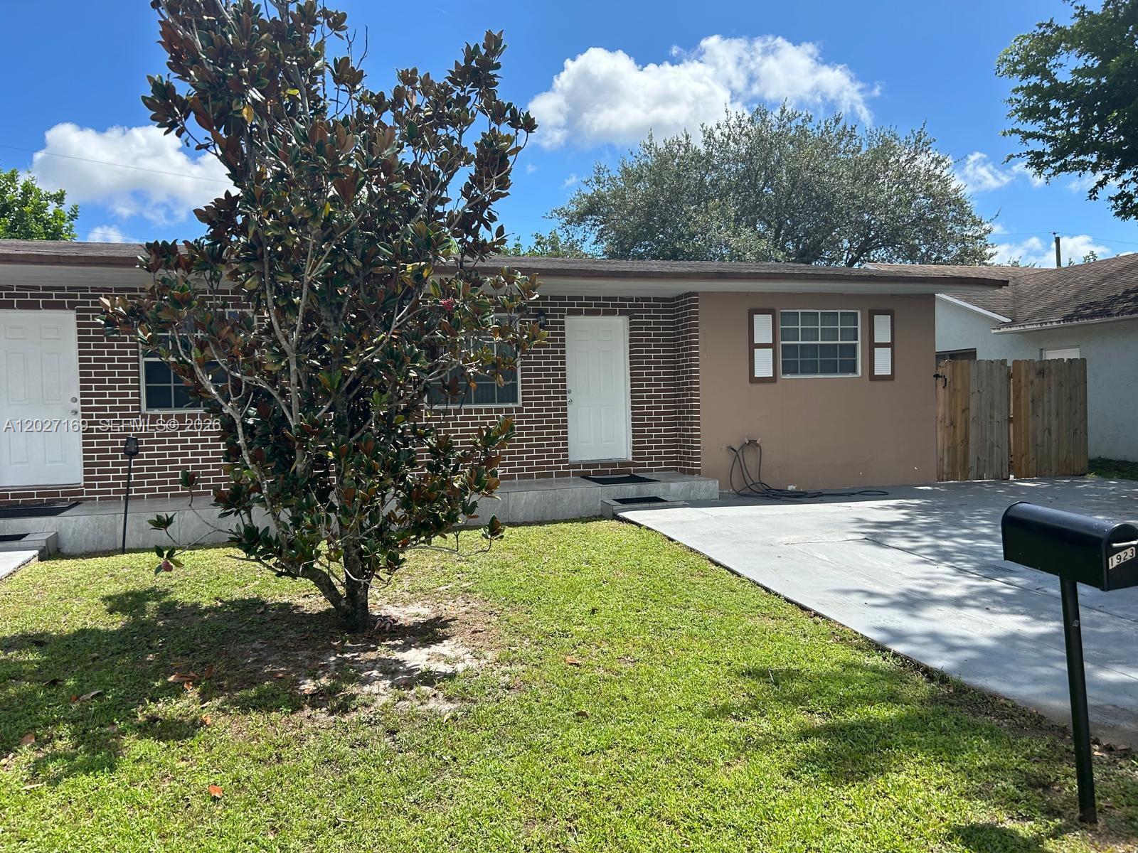 A single-story house with a brick facade, a front lawn, and a concrete driveway — 1923 SW 99th Ter, Miramar FL 33025, MIRAMAR, FL