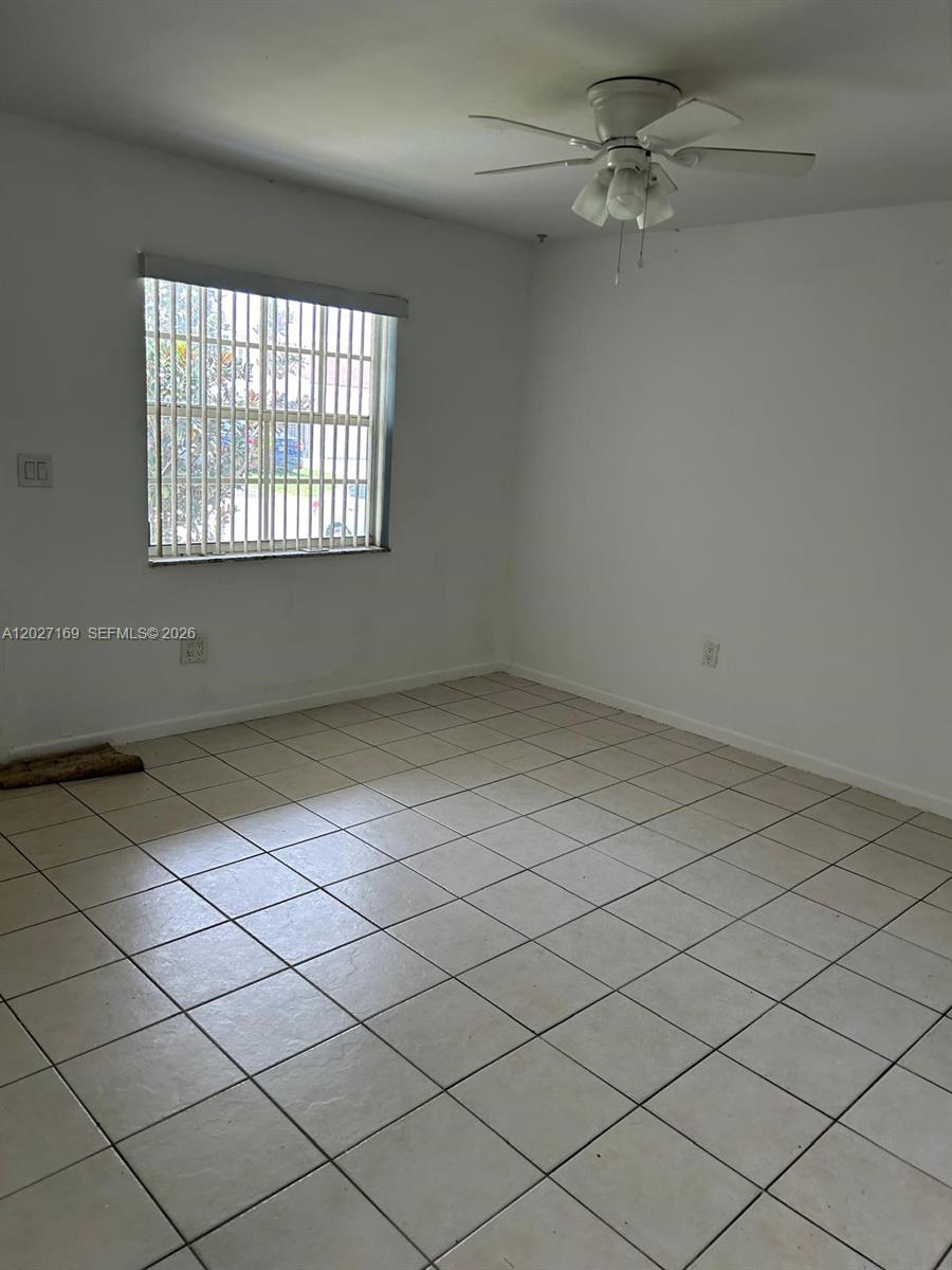 A kitchen features white cabinets, a white stove, a white refrigerator, and a stone-look countertop — 1923 SW 99th Ter, Miramar FL 33025, MIRAMAR, FL