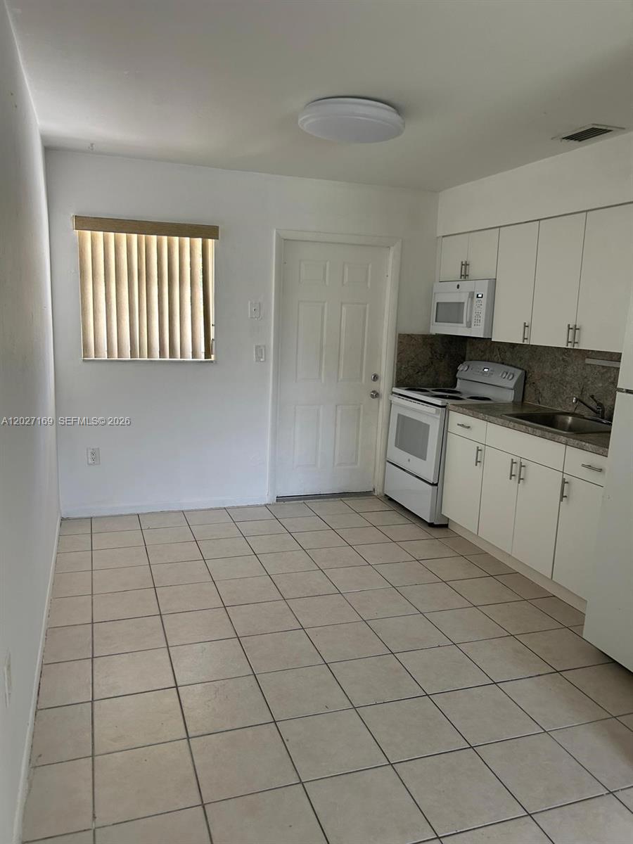 A bathroom features a white vanity with a marble countertop, a toilet, and tile flooring — 1923 SW 99th Ter, Miramar FL 33025, MIRAMAR, FL