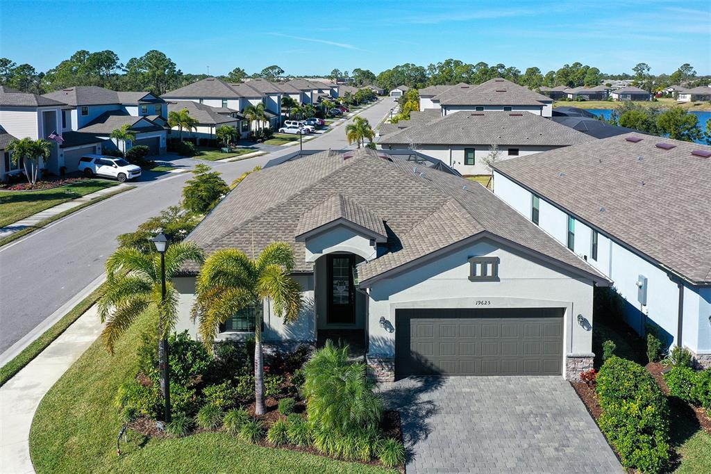 An aerial view shows a single-story suburban house with a gray roof and garage — 19625 FISHHAWK TRAIL, VENICE, FL