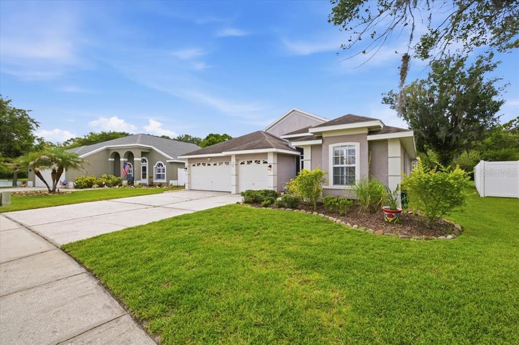 A single-story house with a two-car garage and a landscaped front yard — 392 TAVERNIER CIRCLE, OLDSMAR, FL