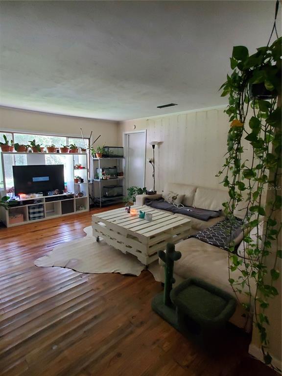 A living room features hardwood floors, a white pallet coffee table, and a large sectional sofa — 23676 NW 194TH AVENUE, HIGH SPRINGS, FL