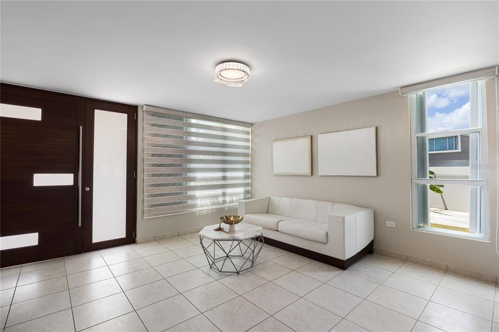 A living room features white tile floors, a white sofa, and a modern front door — P-25 PASEO LAS OLAS, DORADO, PR