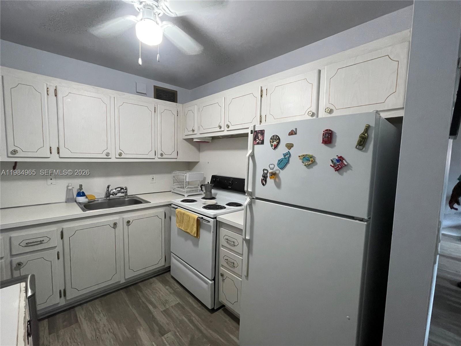 A kitchen features white cabinets, a white stove, a white refrigerator, and a sink — 279 Markham M # M, Deerfield Beach FL 33442, DEERFIELD BEACH, FL
