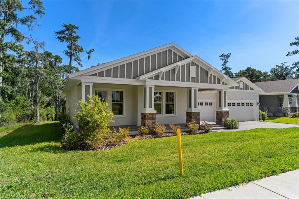 A single-story house with a stone-accented porch, vertical siding, and a two-car garage — 6671 SUMMIT VIEW DRIVE, BROOKSVILLE, FL