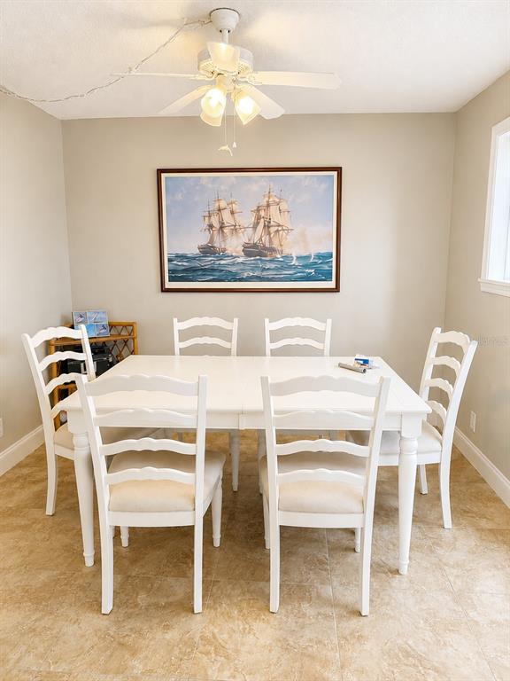 A kitchen with white cabinets, stainless steel appliances, and light-colored tile flooring — 1 KEY CAPRI UNIT 102W, TREASURE ISLAND, FL