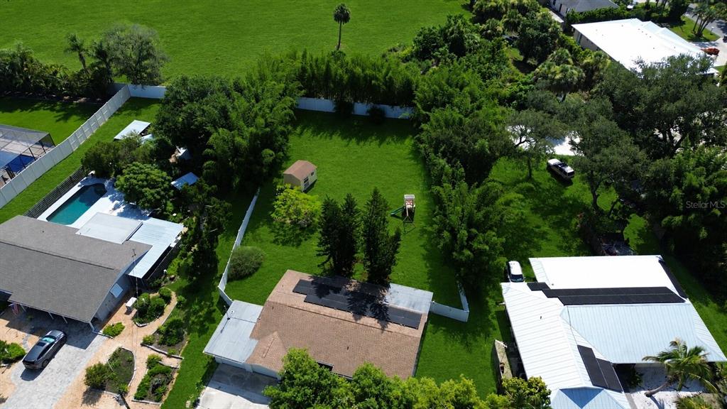 An aerial view shows a residential backyard with a lawn, shed, and playground equipment — 329 BAY VISTA AVENUE, OSPREY, FL
