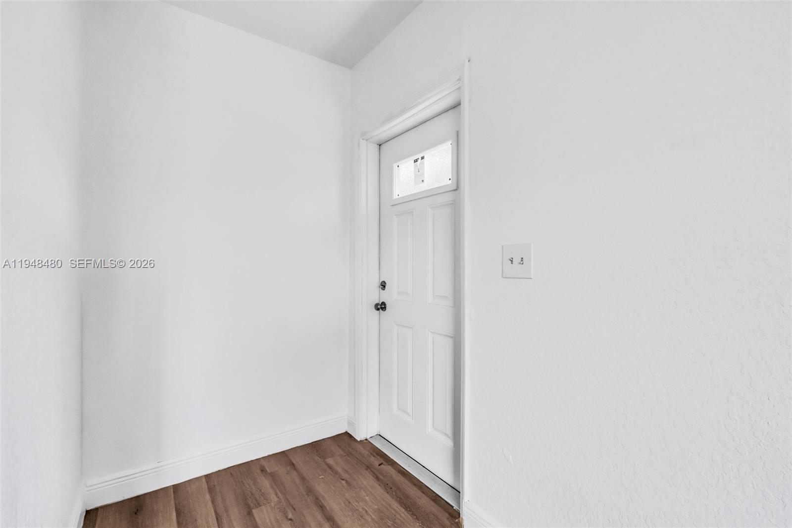 A white interior entryway features a single door with a window and wood-look flooring — 8329 NW 5th Ave # 1, Miami FL 33150, MIAMI, FL