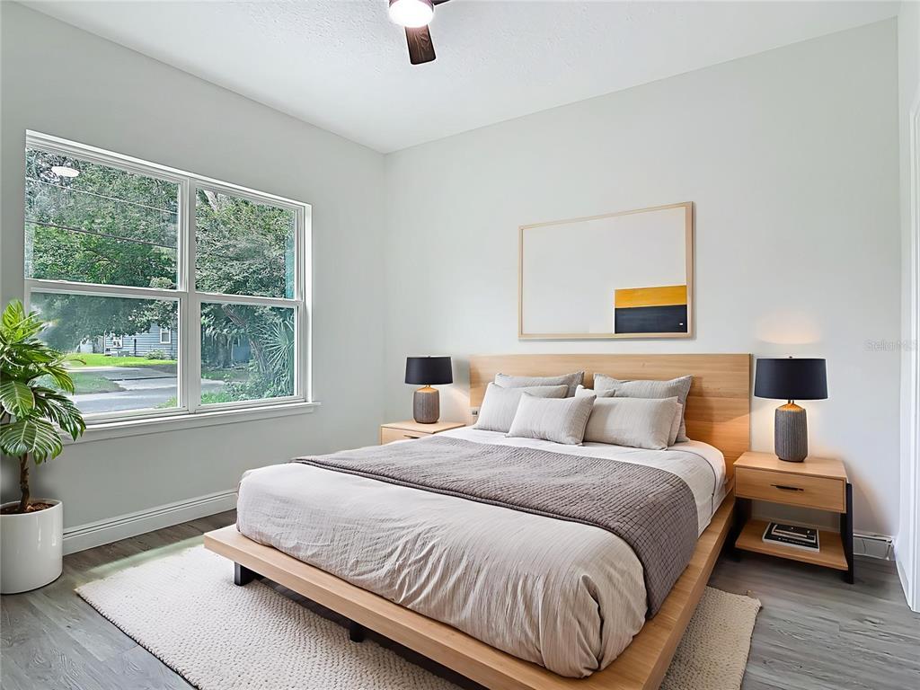 A bedroom features a platform bed with light wood accents, gray bedding, and a large window — 2445 DOLARWAY STREET, SANFORD, FL