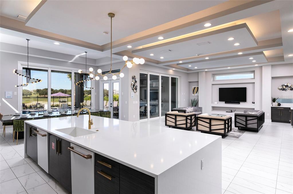 A modern open-concept kitchen and living area featuring a large white quartz island — 1514 COROLLA COURT, REUNION, FL