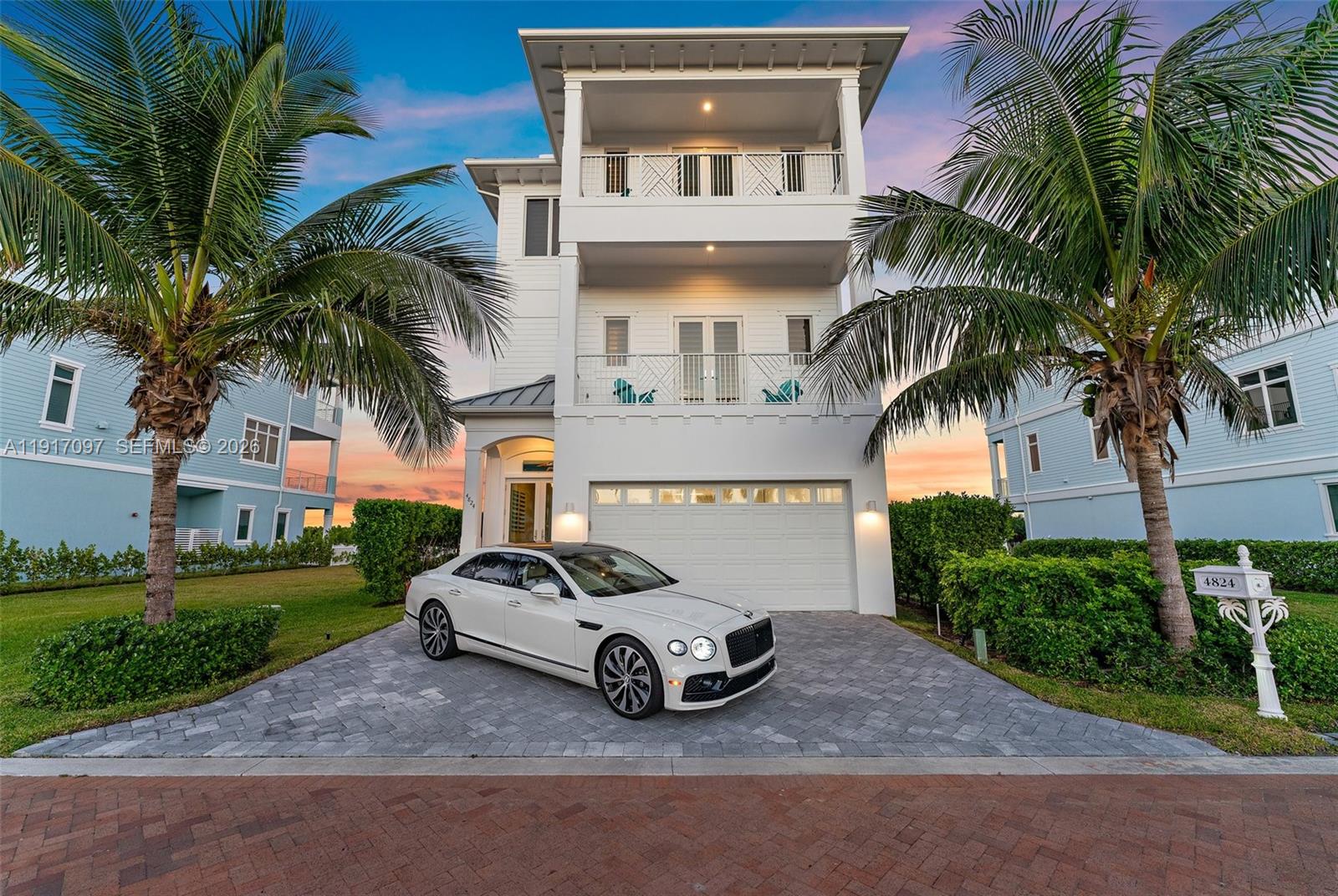 A white three-story house with a paved driveway and a parked car in front — 4824 Watersong Way, Fort Pierce FL 34949, FORT PIERCE, FL
