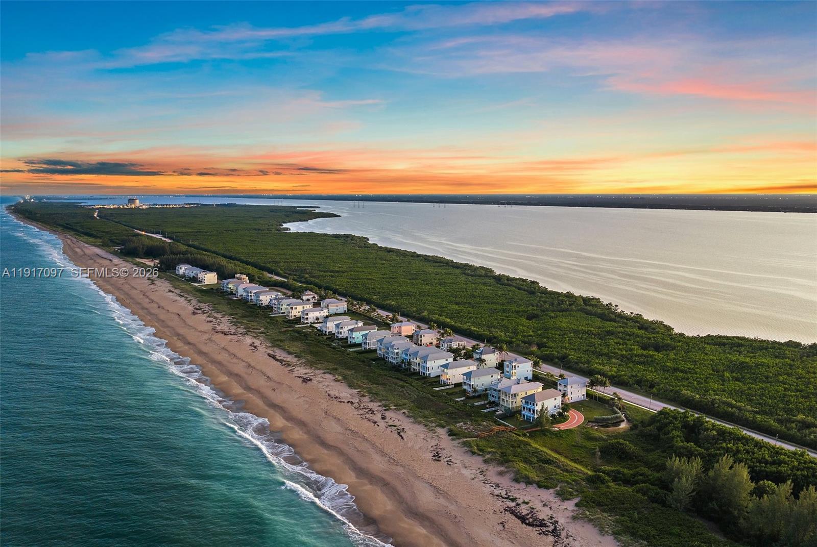 An aerial view shows a row of coastal houses situated between the ocean and a forest — 4824 Watersong Way, Fort Pierce FL 34949, FORT PIERCE, FL