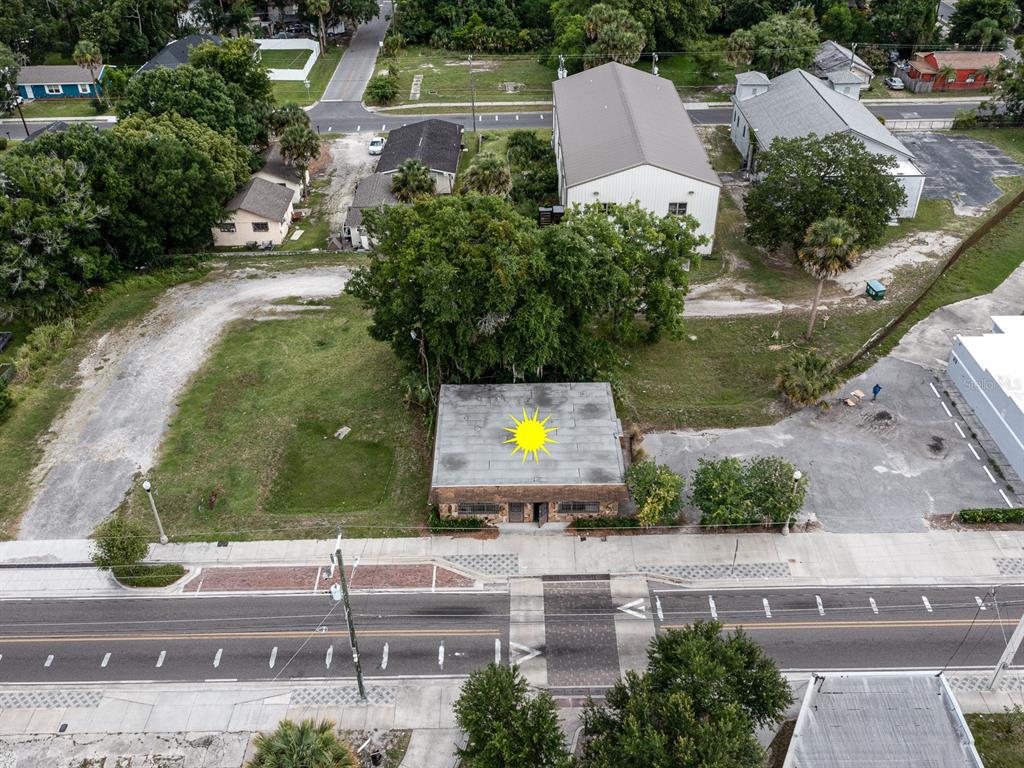 An aerial view shows a flat-roofed building on a lot next to a paved road — 1204 HISTORIC GOLDSBORO BOULEVARD, SANFORD, FL