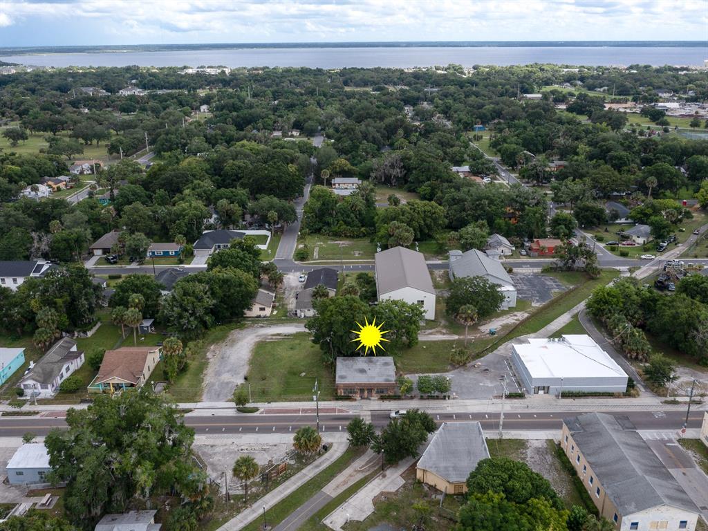 An aerial view shows a brick building with a sun icon in a suburban neighborhood — 1204 HISTORIC GOLDSBORO BOULEVARD, SANFORD, FL