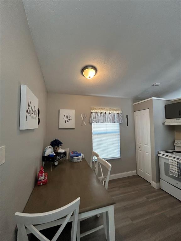A dining area features a wooden table, white chairs, light gray walls, and wood-look flooring — 1395 COX AVENUE NW, PALM BAY, FL