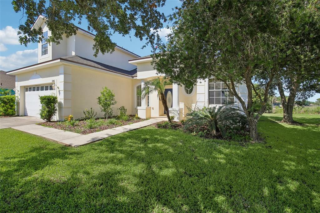 A two-story house with a yellow exterior, a garage, and a front walkway — 2265 LONG VIEW CIRCLE, BROOKSVILLE, FL