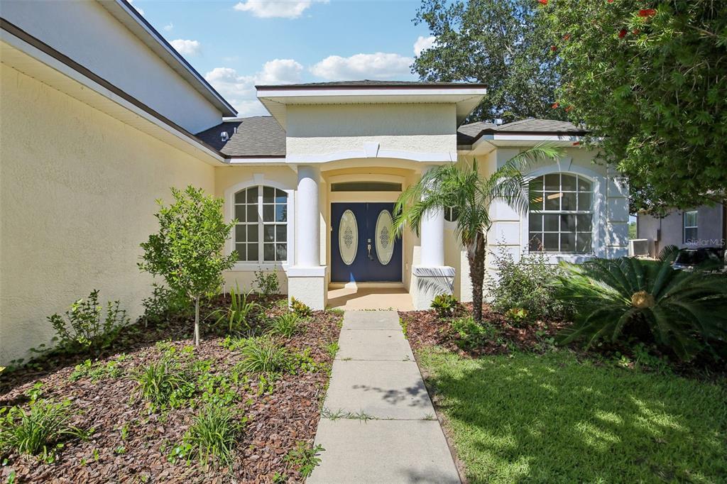 A single-story house with a blue double front door, white columns, and a concrete walkway — 2265 LONG VIEW CIRCLE, BROOKSVILLE, FL