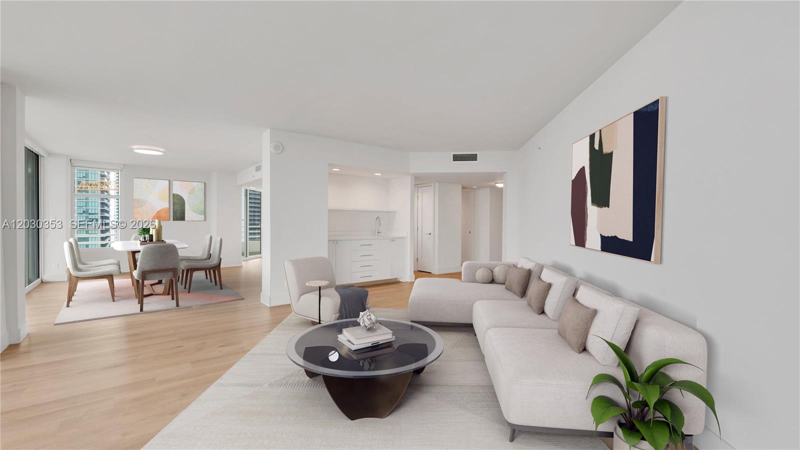 This living and dining area features light wood floors, a sectional sofa, and a wet bar — 555 NE 34th St # 1601, Miami FL 33137, MIAMI, FL