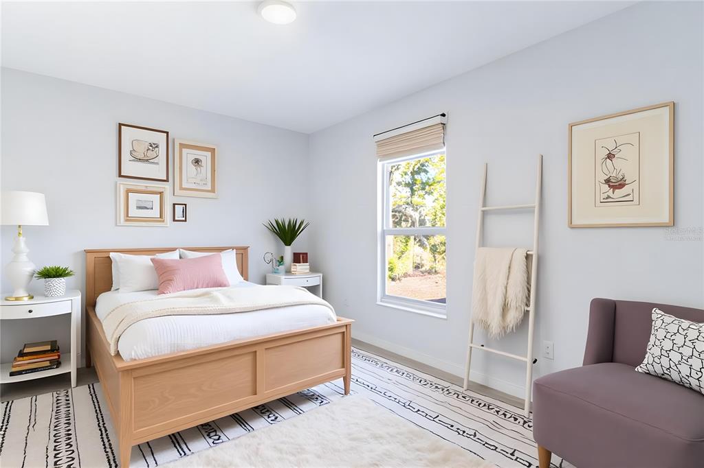 A bedroom features a wooden bed, a purple armchair, and a window with a blanket ladder — 1403 BITTERSWEET STREET, LAKE PLACID, FL