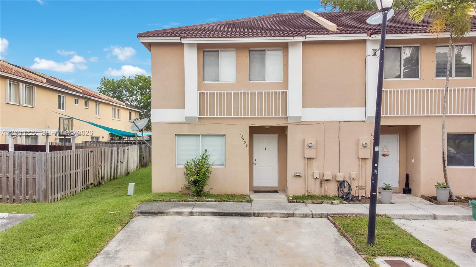 A two-story beige townhouse with a concrete driveway and a small front yard — 13909 SW 178th St # 1, Miami FL 33177, MIAMI, FL