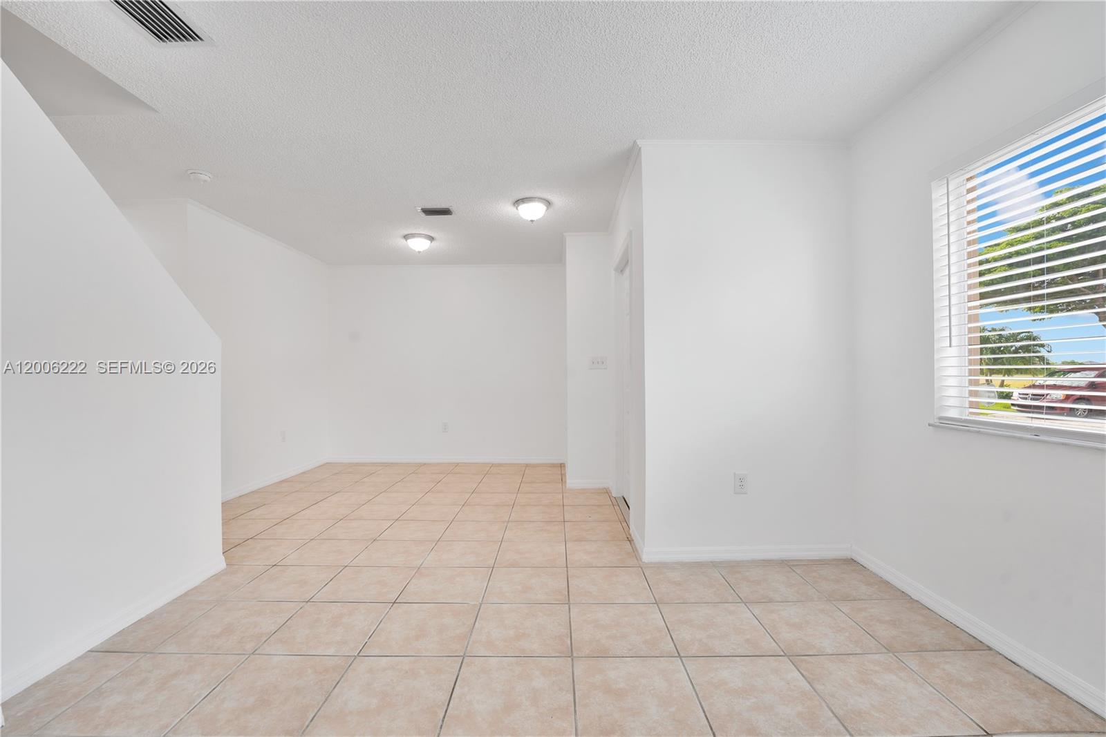 An empty room with white walls, beige tile flooring, and a window with blinds — 13909 SW 178th St # 1, Miami FL 33177, MIAMI, FL