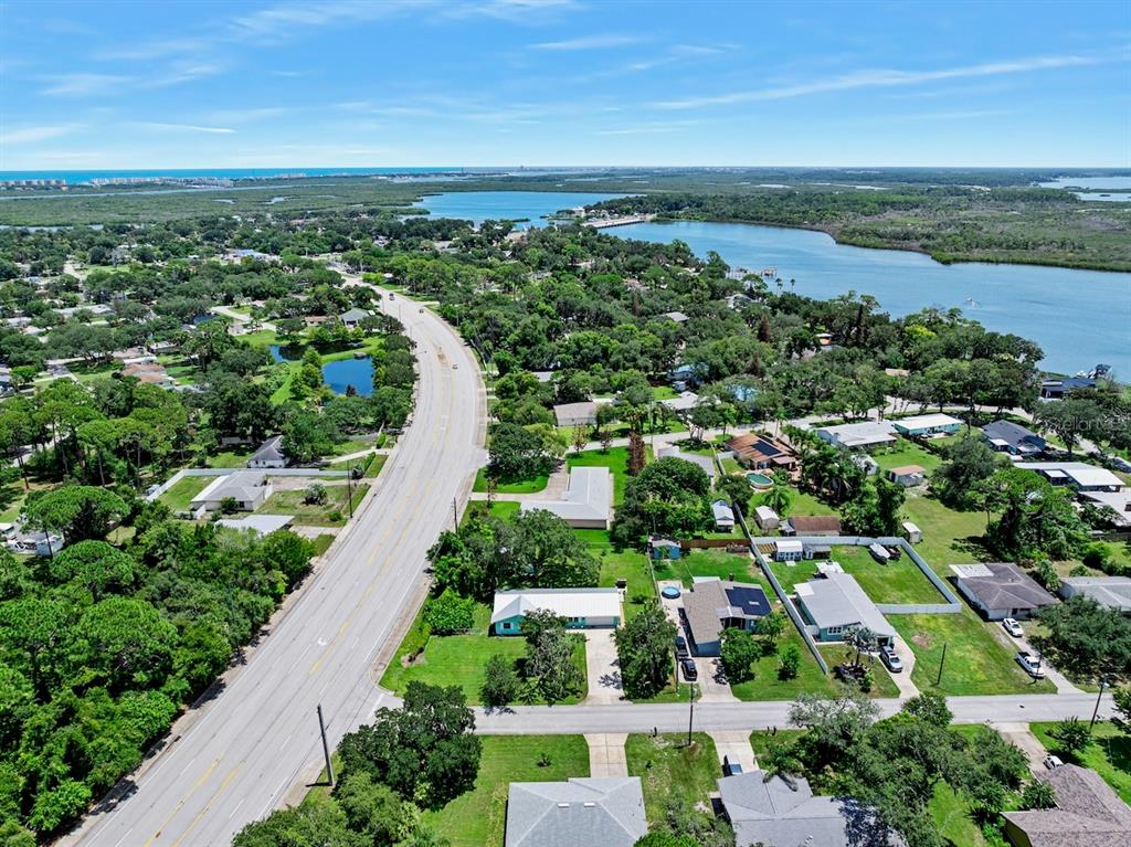 An aerial view shows a road winding through a residential neighborhood near a coastal waterway — 311 ACACIA DRIVE, PORT ORANGE, FL