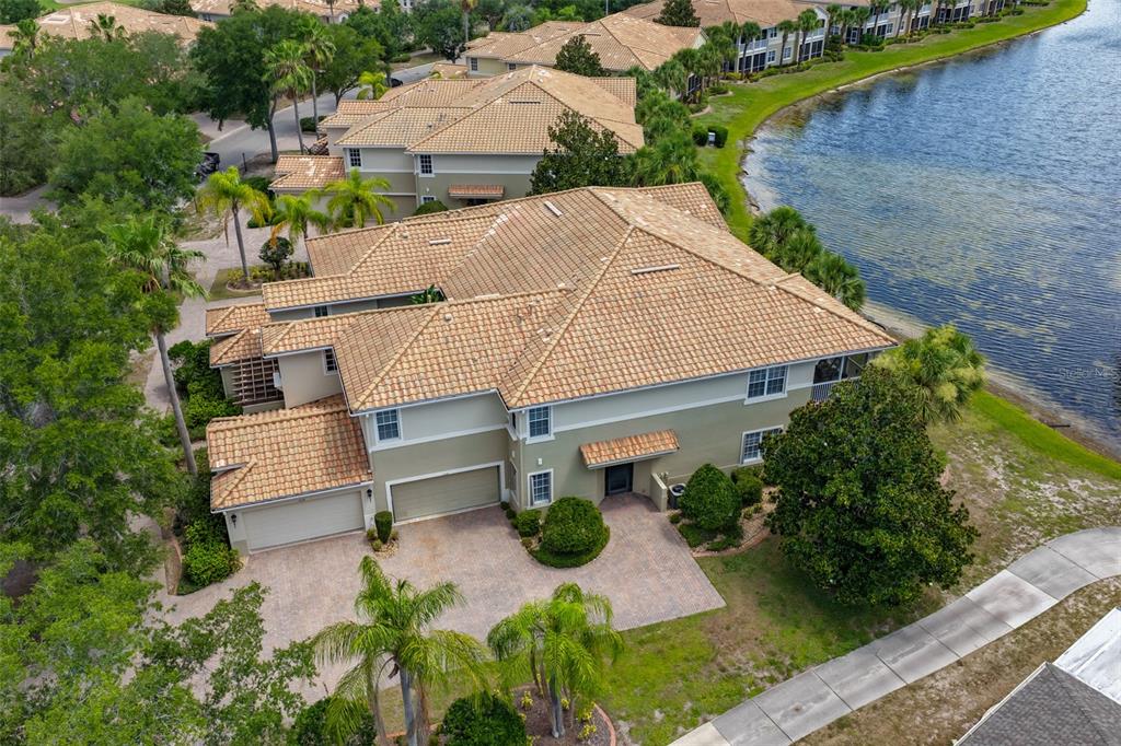 An aerial view of a two-story house with a tiled roof and a paved driveway — 1440 EMERALD DUNES DRIVE, SUN CITY CENTER, FL
