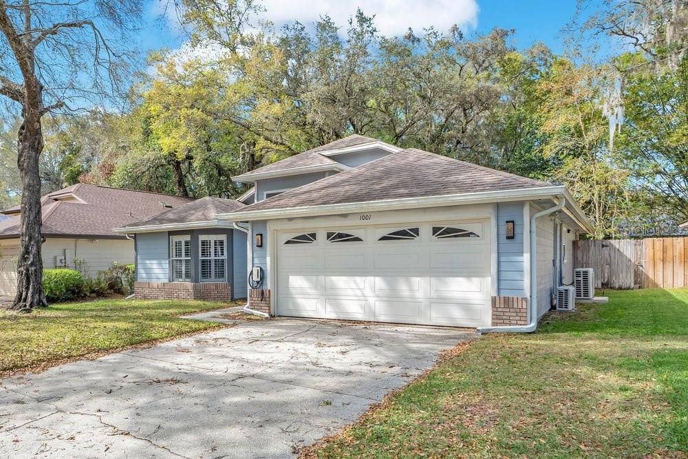 A light blue single-story house with a white two-car garage and a concrete driveway — 1001 PIEDMONT OAKS DRIVE, APOPKA, FL