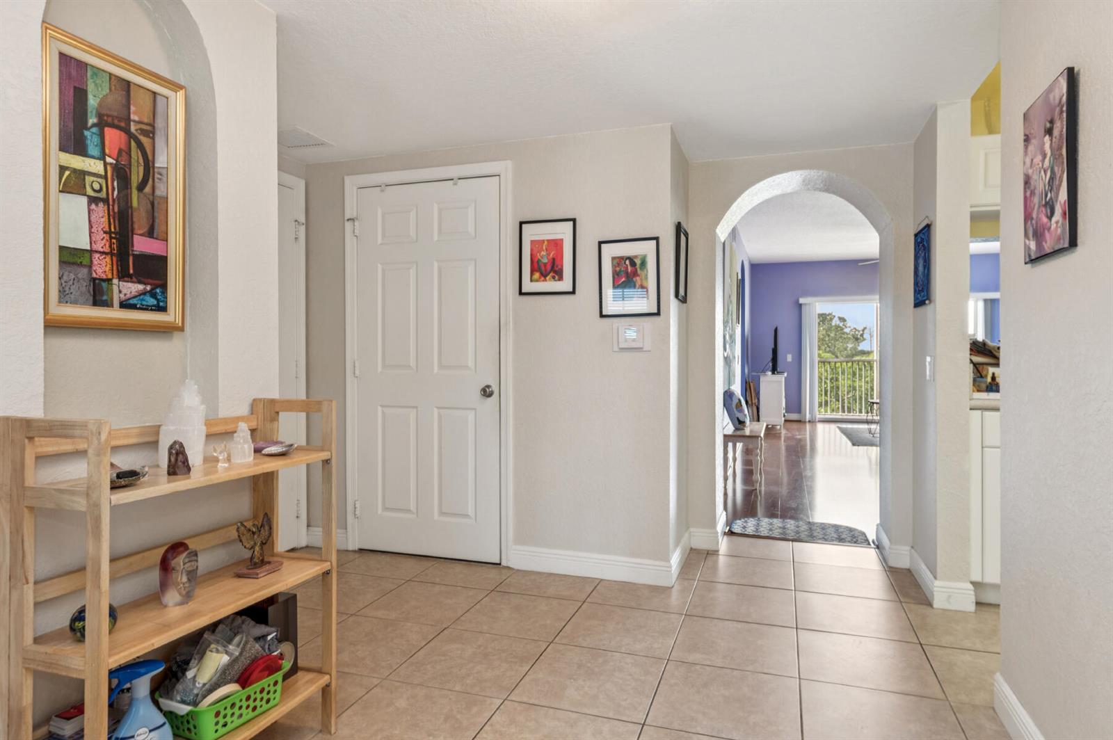 A tiled entryway features a wooden shelf, a white door, and an arched doorway leading inside — 4721 E Lucerne Lakes Blvd E # 744, Lake Worth FL 33467, LAKE WORTH, FL