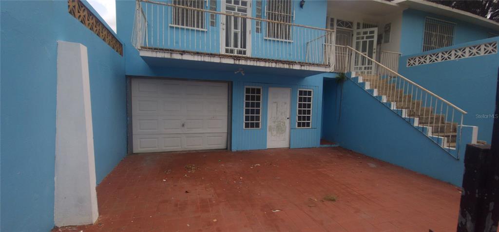 A blue two-story house features a garage, a ground-level door, and an exterior staircase — Carrt. 367 Klm 0.7 BO MACHUCAL, SECTOR PAPAYO, SABANA GRANDE, PR