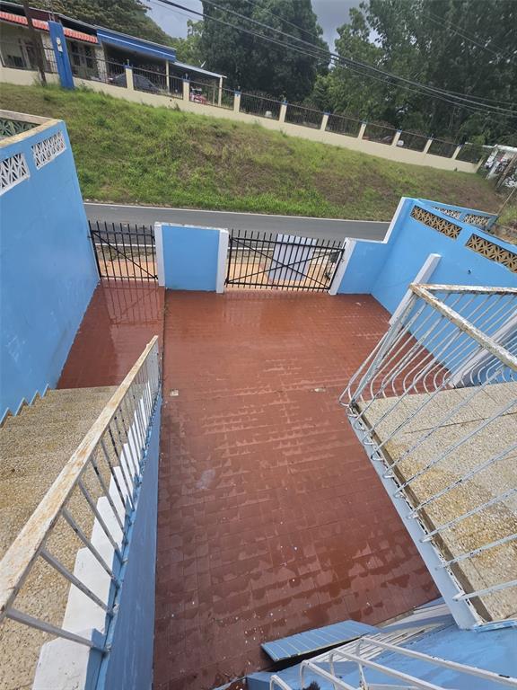 An elevated view of a tiled outdoor patio enclosed by blue walls and metal railings — Carrt. 367 Klm 0.7 BO MACHUCAL, SECTOR PAPAYO, SABANA GRANDE, PR