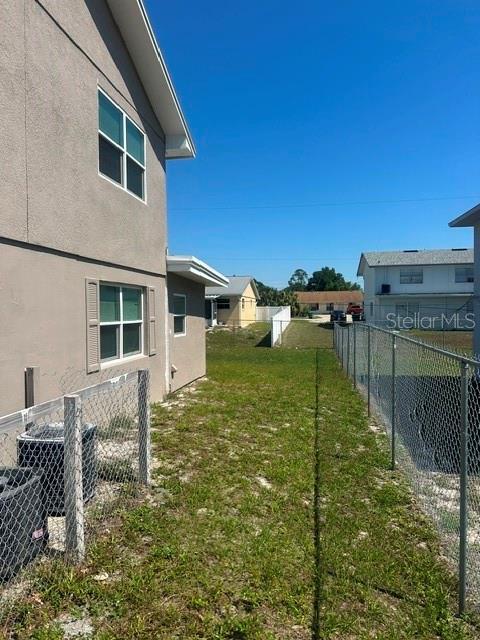 A view of a side yard between two houses with a chain-link fence — 112 CARIBBEAN STREET, DELTONA, FL
