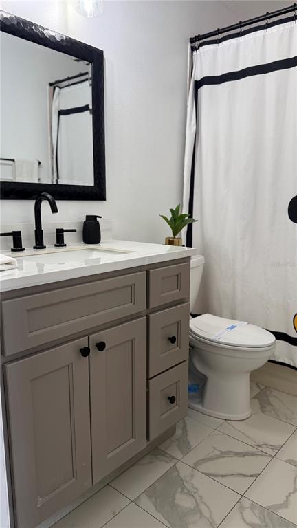 A bathroom features a gray vanity, a black-framed mirror, and a white shower curtain — 226 ORCHID DRIVE, DAVENPORT, FL
