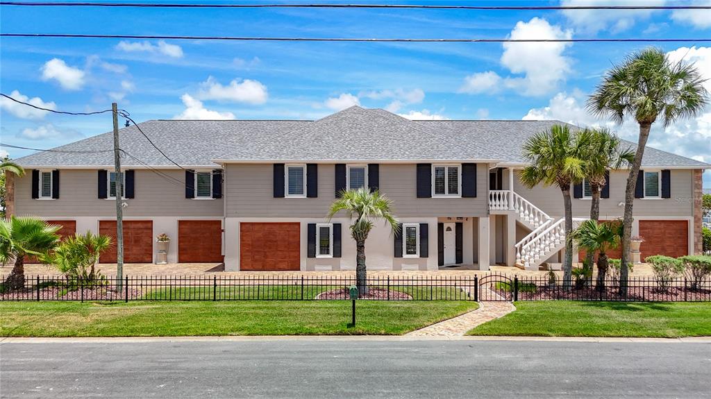 A two-story house with a gray exterior, multiple garage doors, and a white staircase — 4146 DIAZ COURT, HERNANDO BEACH, FL