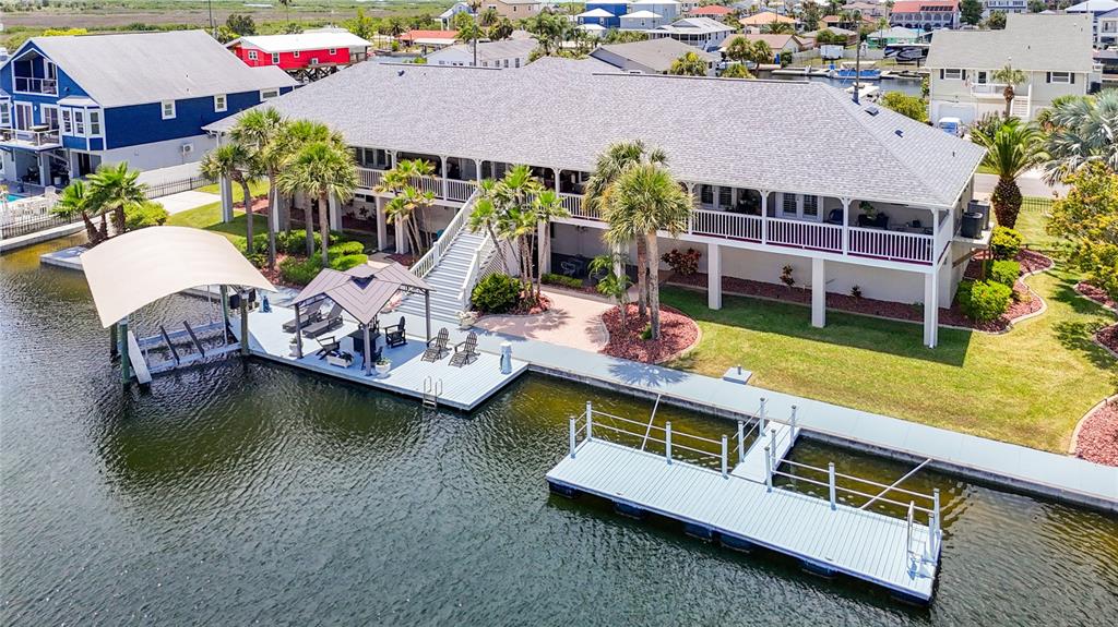 An elevated waterfront house features a large deck, a boat lift, and a private dock — 4146 DIAZ COURT, HERNANDO BEACH, FL