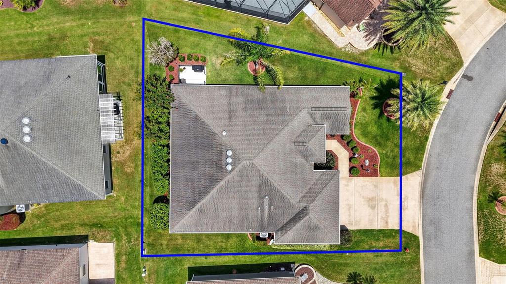An aerial view shows a house with a gray roof on a landscaped lot — 1583 LEMON LOOP, THE VILLAGES, FL