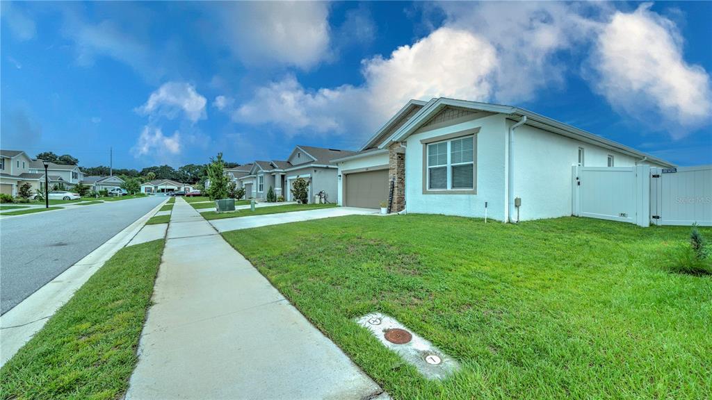 A single-story suburban house with a white stucco exterior and a tan garage — 1228 MATTIE POINTE BOULEVARD, AUBURNDALE, FL