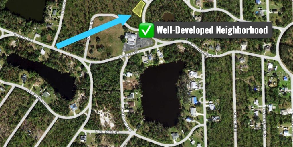 This is an aerial map showing a vacant lot highlighted in yellow within a residential neighborhood — 12069 HOLLYHOCK STREET, PUNTA GORDA, FL