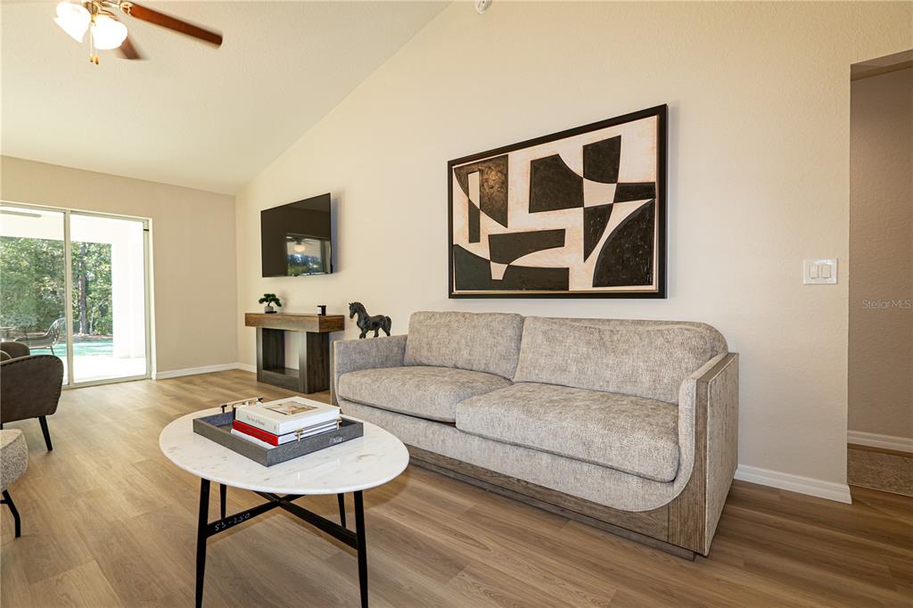 A living room features a gray sofa, a marble coffee table, and abstract wall art — 6920 SW 209TH AVENUE, DUNNELLON, FL