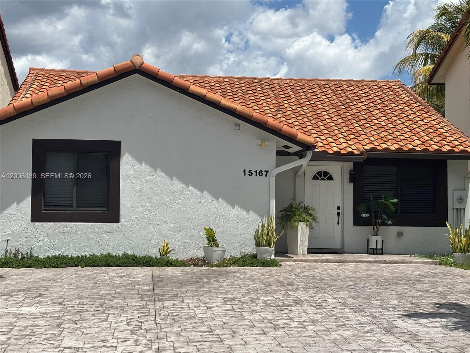 A single-story house with a white stucco exterior, terracotta roof tiles, and a paved driveway — 15167 SW 94th Ter # 1, Miami FL 33196, MIAMI, FL