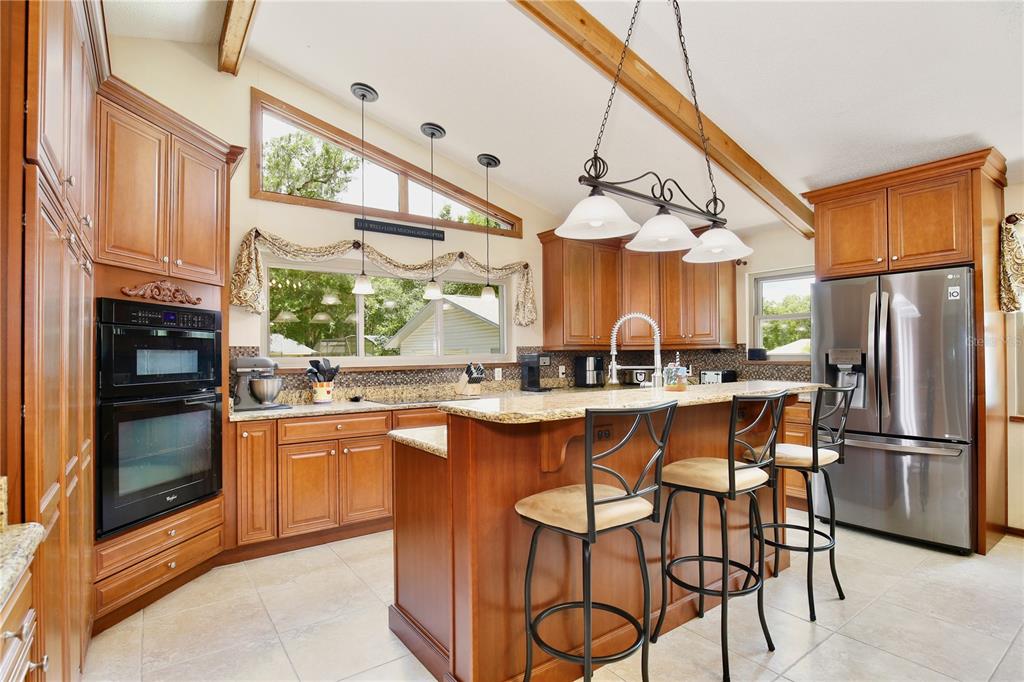 A kitchen features wood cabinets, granite countertops, a double wall oven, and a kitchen island — 106 POLO LANE, SANFORD, FL