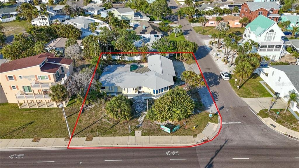 An aerial view shows a single-story house with a pool on a corner lot — 16007 GULF BOULEVARD, REDINGTON BEACH, FL