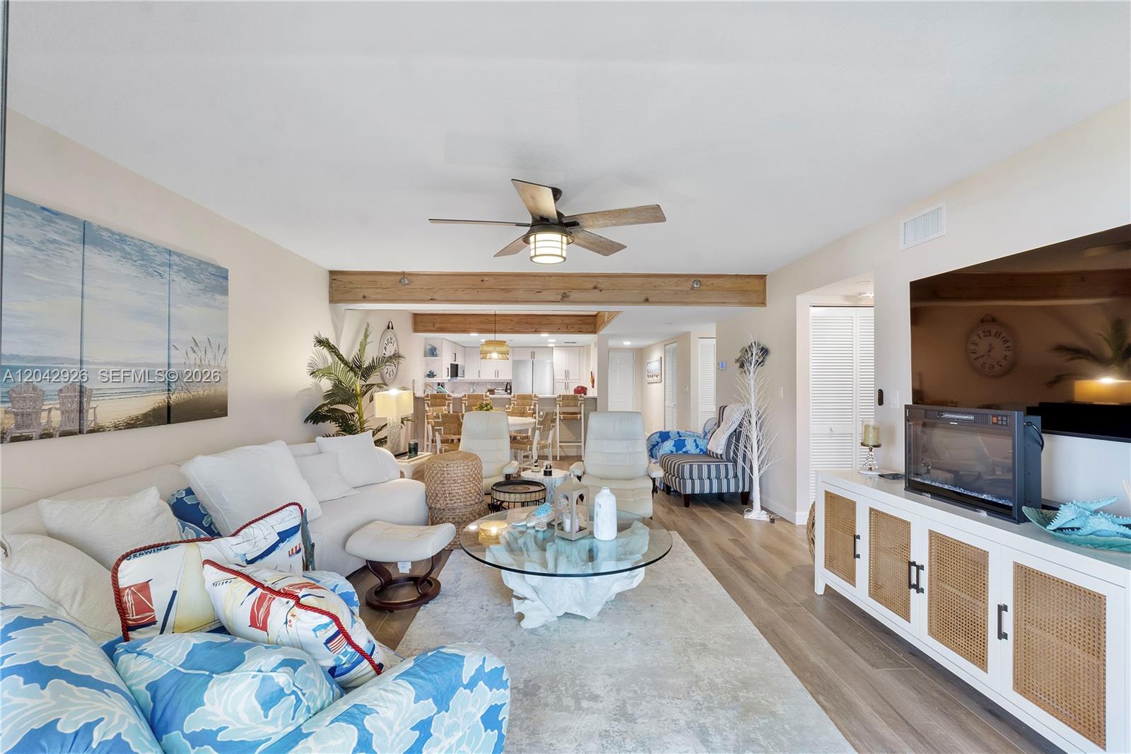 A living room features a white sofa, a glass coffee table, and exposed wooden ceiling beams — 522 Oak Harbour Dr # 522, Juno Beach FL 33408, JUNO BEACH, FL