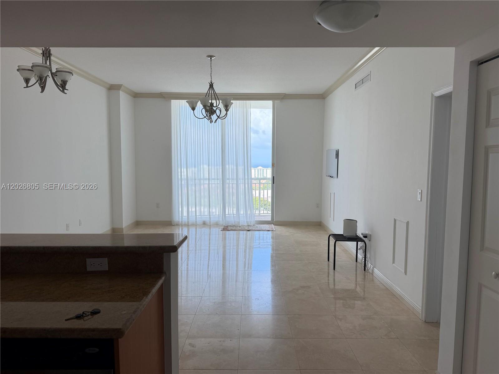 An open-concept living area features tile flooring, a chandelier, and a balcony with ocean views — 1755 E Hallandale Beach Blvd # 2404E, Hallandale Beach FL 33009, HALLANDALE BEACH, FL