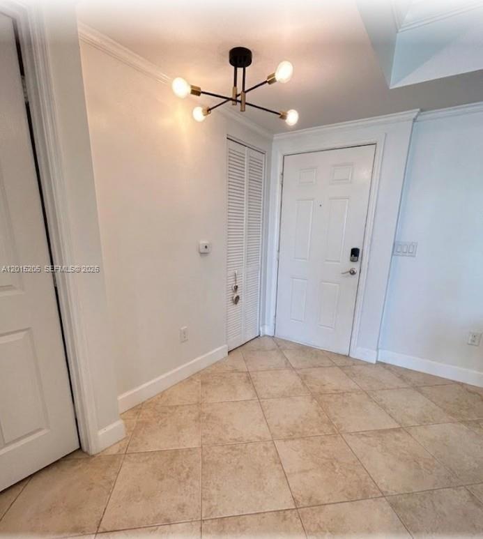 An entryway features a modern light fixture, white doors, and light-colored tile flooring — 625 Casa Loma Blvd # 1009, Boynton Beach FL 33435, BOYNTON BEACH, FL